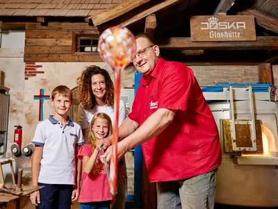 Glasblasen bei JOSKA © JOSKA Kristall GmbH Co.KG ein Glasbläser zeigt den Gästen die Handwerkskunst