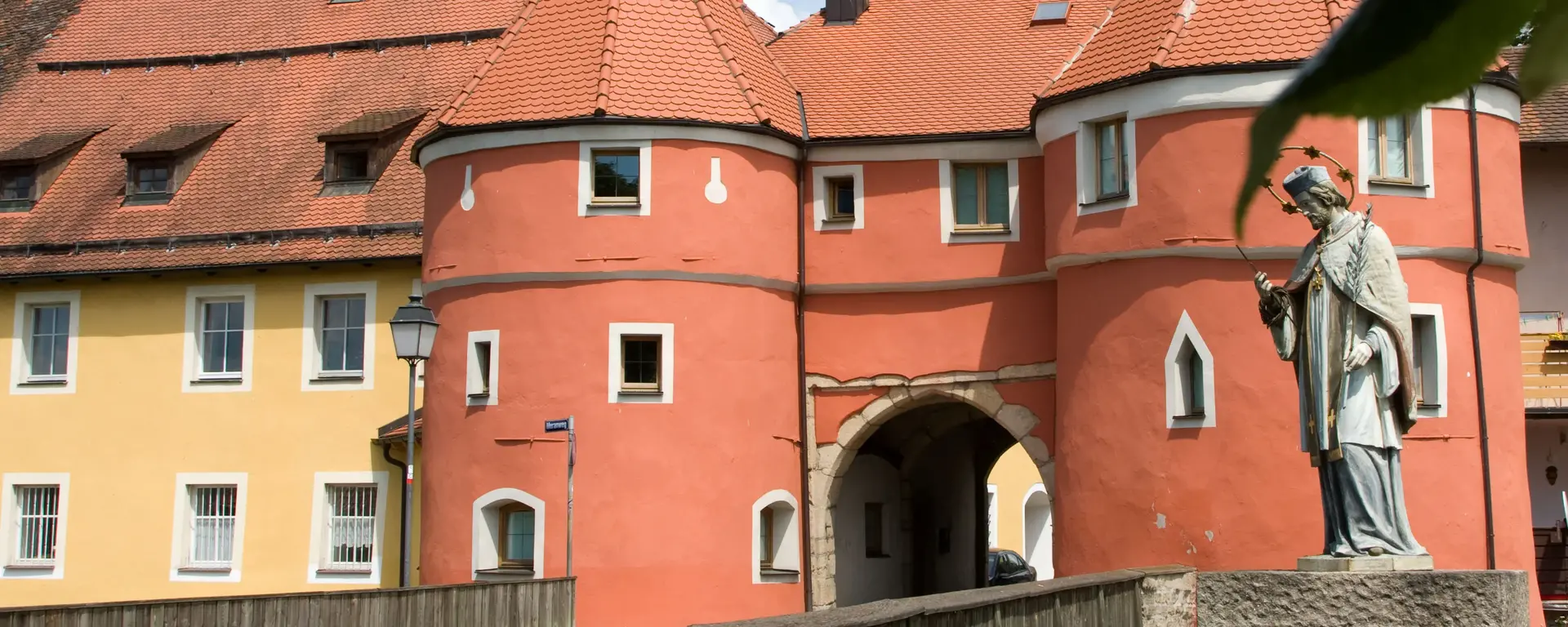 Zufahrt in die Stadt Cham durch das Biertor gesäumt von zwei roten Türmen   