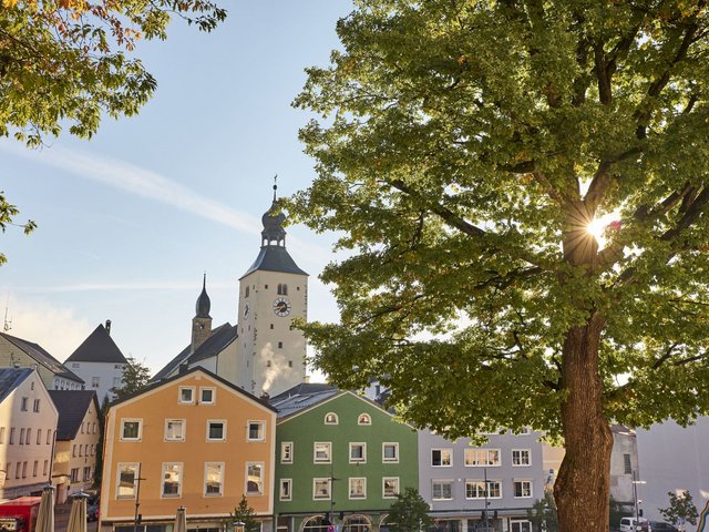 Blick vom Stadtplatz Regen auf die farbige Häuserfront im Hintergrund die Stadtpfarrkirche